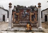 Ảnh chụp hai bé gái đứng trước một bức Trấn Phong thời Nguyễn. Tâm Trấn Phong khắc nổi hình linh thú.